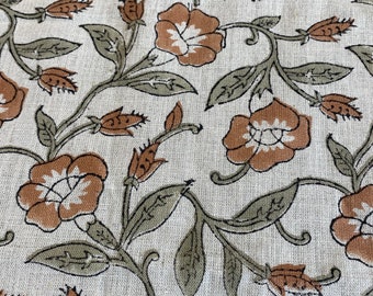Puede incluir: Una tela beige con un patrón repetitivo de flores marrones y hojas verdes. La tela tiene una textura sutil.