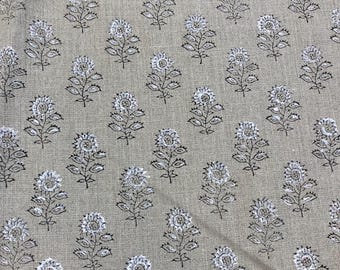 Puede incluir: Una tela beige con un patrón repetido de diseños florales blancos y negros.