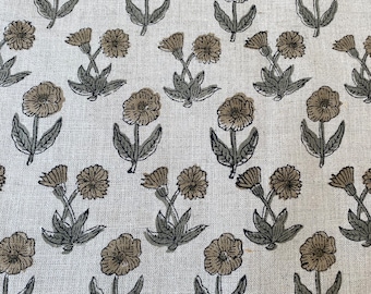 Puede incluir: Tela blanquecina con un patrón floral repetido. Las flores son en tonos marrones y beige, con hojas y tallos verdes. El diseño está uniformemente distribuido por la tela.