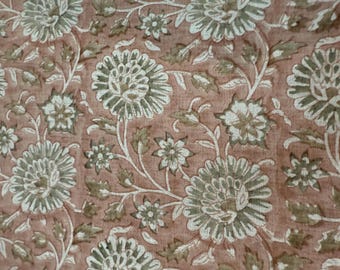 Op de afbeelding: Een roze stof met een wit en groen bloemenpatroon. De stof heeft een vintage uitstraling en gevoel.
