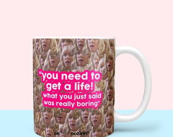 May include: White ceramic mug with a pink quote that reads "you need to get a life! what you just said was really boring" and the text "ohweetsoccurin?" at the bottom. The mug is covered in a pattern of a woman's face.