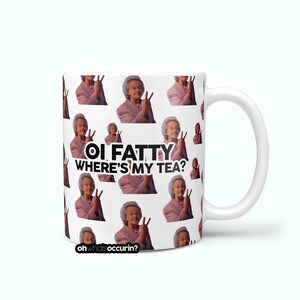 May include: White ceramic mug with a repeating pattern of an elderly woman in a pink suit making a peace sign. The mug features the text "OI FATTY WHERE'S MY TEA?" in black and white, with the website "ohwhatsoccurin?" at the bottom.