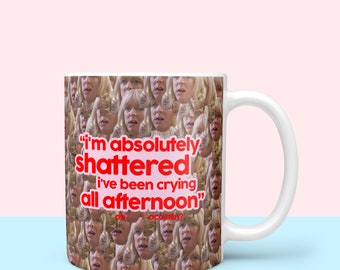 May include: White ceramic mug with a repeating pattern of a woman's face. The mug has red text that reads "I'm absolutely shattered I've been crying all afternoon."