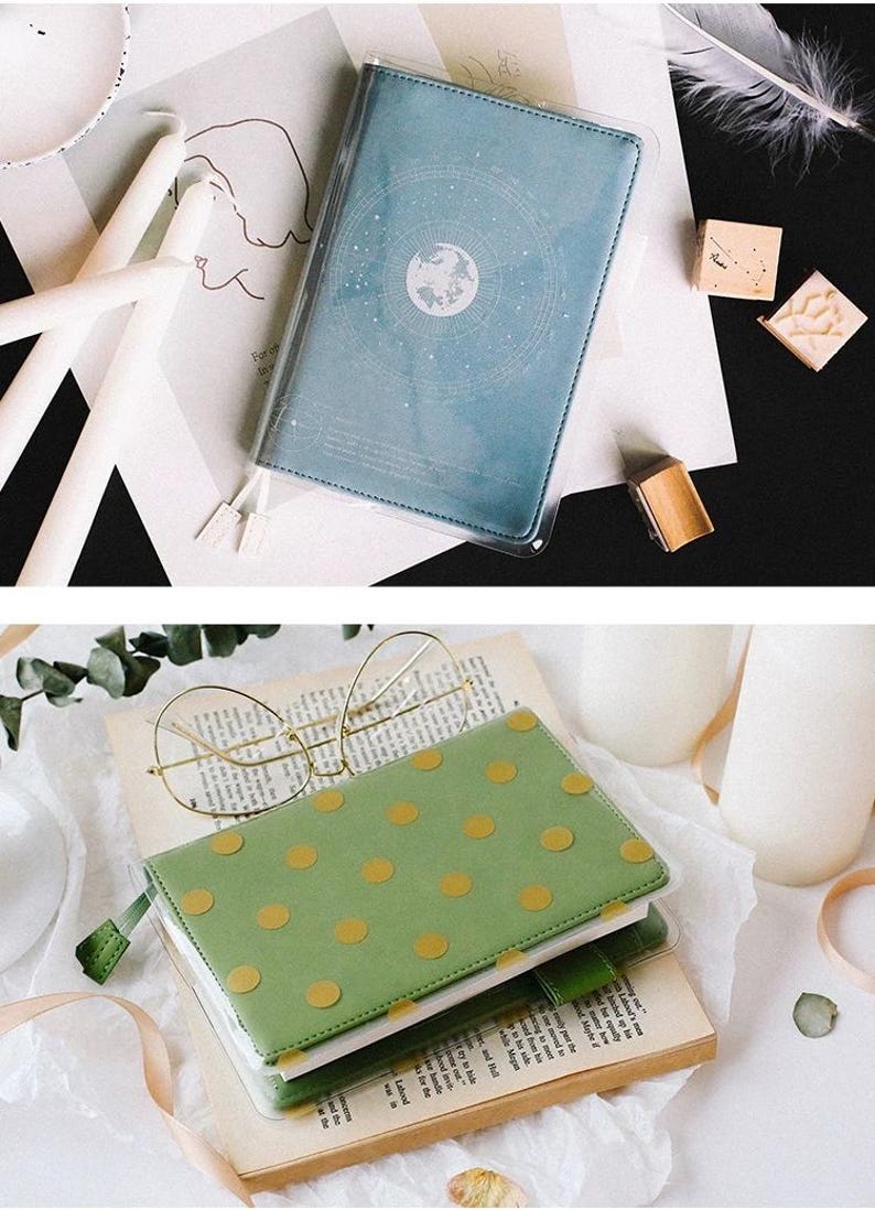 Puede incluir: Dos cuadernos con cubiertas de pl&aacute;stico transparente. El cuaderno de arriba tiene una cubierta azul con un dise&ntilde;o blanco de un globo terr&aacute;queo rodeado de estrellas. El cuaderno de abajo tiene una cubierta verde con un patr&oacute;n de lunares dorados.