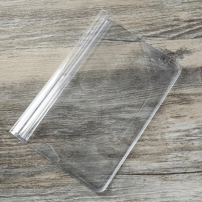 Puede incluir: Un protector de hojas de pl&aacute;stico transparente con un borde doblado. El protector est&aacute; dise&ntilde;ado para contener y proteger documentos o papeles.