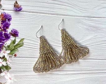 May include: A pair of gold beaded earrings with a fan-shaped design. The earrings are hanging from silver hooks.