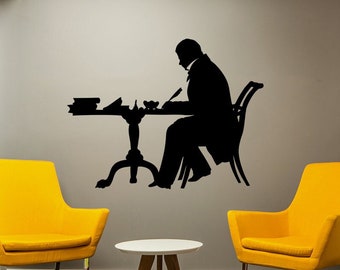 May include: Two yellow chairs and a small white table with wooden legs in a room with a gray wall. A black silhouette of a person sitting at a desk is on the wall. The wall behind one chair has a colorful geometric pattern.