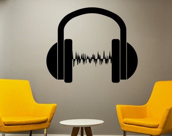 May include: Two yellow chairs and a small round table in a room with a black and white headphone graphic on the wall. The wall behind one chair has a colorful geometric pattern.