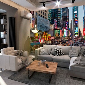 May include: A living room with a gray sectional sofa and a white armchair. The wall behind the sofa features a mural of Times Square in New York City at night. The mural is filled with bright lights and advertisements.