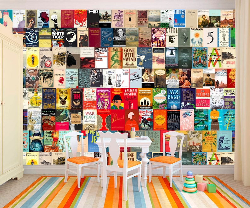 May include: A white wall with a colorful collage of book covers. The wall is decorated with a variety of books, including classics, contemporary fiction, and non-fiction. The books are arranged in a grid pattern, and the colors are bright and vibrant. There are three white chairs and a white table in front of the wall. The floor is covered in a striped rug with orange, blue, and white stripes. There are a few colorful wooden blocks on the floor.