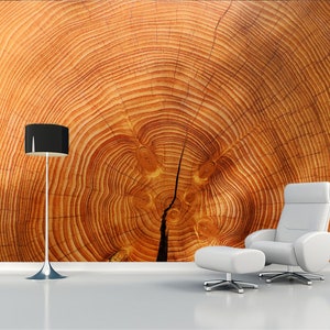 May include: A white armchair and ottoman with a wood grain background. The wood grain is a close-up of a tree trunk with concentric rings.