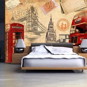 May include: A vintage-inspired bedroom design featuring a red telephone booth, a red double-decker bus, and a sketch of the Tower Bridge. The wall is decorated with old postcards and stamps. A white bed with a white duvet is in the foreground.
