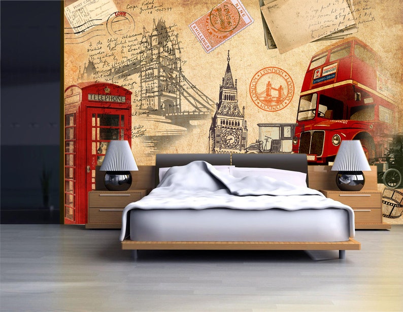 May include: A vintage-inspired bedroom design featuring a red telephone booth, a red double-decker bus, and a sketch of the Tower Bridge. The wall is decorated with old postcards and stamps. A white bed with a white duvet is in the foreground.