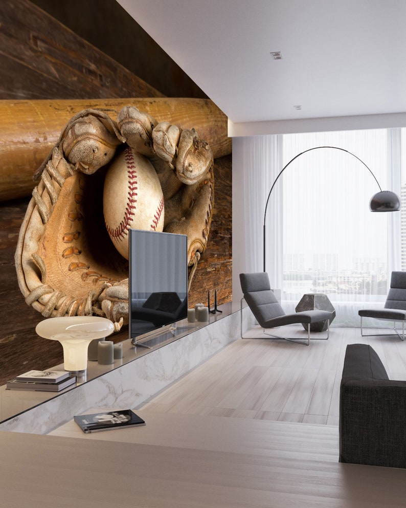 May include: A baseball mitt with a baseball inside, resting on a wooden surface with a baseball bat behind it. The mitt is brown leather with white stitching. The baseball is white with red stitching. The bat is brown wood.