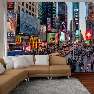 May include: A photo mural depicting a bustling Times Square in New York City at night. The image features towering buildings with bright, colorful billboards and advertisements. The street below is filled with people and traffic.