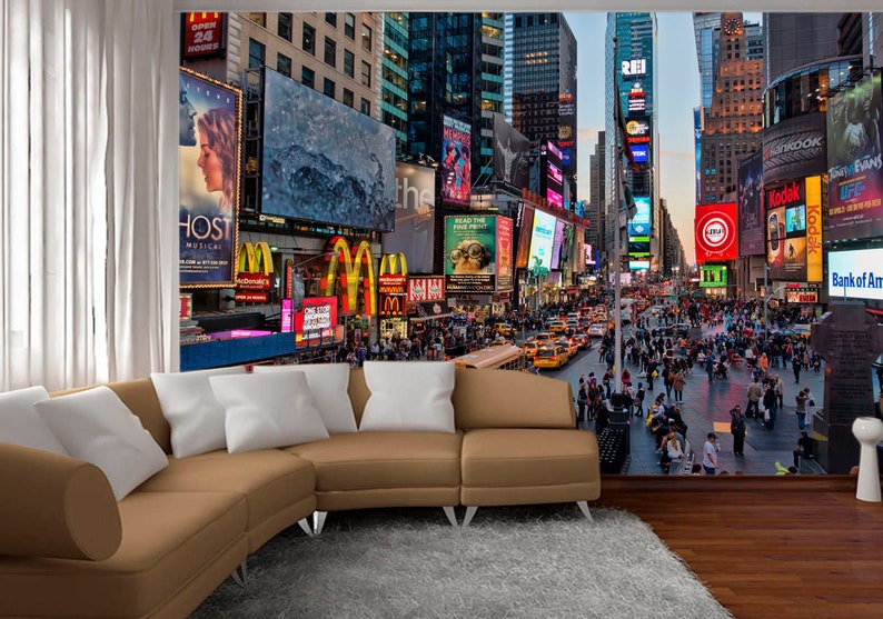 May include: A photo mural depicting a bustling Times Square in New York City at night. The image features towering buildings with bright, colorful billboards and advertisements. The street below is filled with people and traffic.