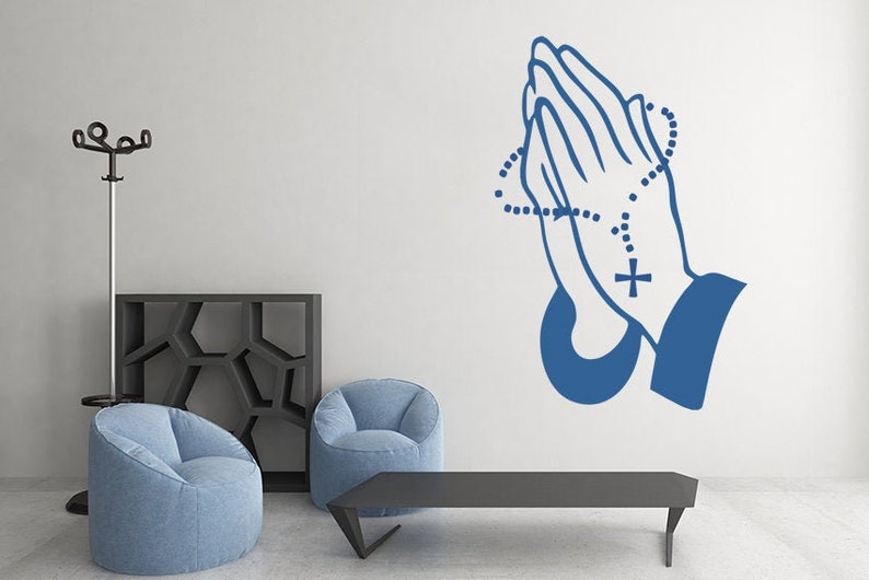 May include: Blue wall decal of two hands clasped in prayer with a rosary around the wrists. The rosary has a cross at the end.