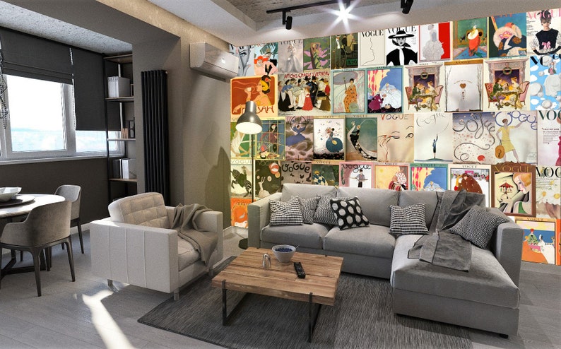 May include: A living room interior with a gray sectional sofa, a white armchair, a coffee table, and a dining table with chairs. The wall behind the sofa is covered with a collage of vintage Vogue magazine covers.