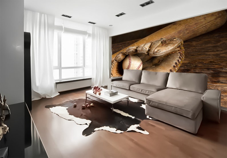 May include: A brown leather baseball glove with a baseball inside, resting on a wooden surface. A wooden baseball bat is behind the glove.