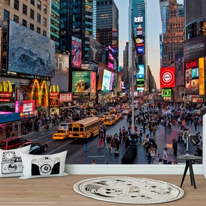 May include: A busy street scene in New York City with tall buildings, bright lights, and many people walking around. There are many billboards and signs with advertisements for various businesses, including McDonald's, Kodak, and Bank of America.