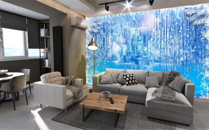 Op de afbeelding: Een woonkamer met een grijze hoekbank, een witte fauteuil en een houten salontafel. De muur achter de bank heeft een grote muurschildering van een blauw ijs kasteel in een besneeuwd bos.