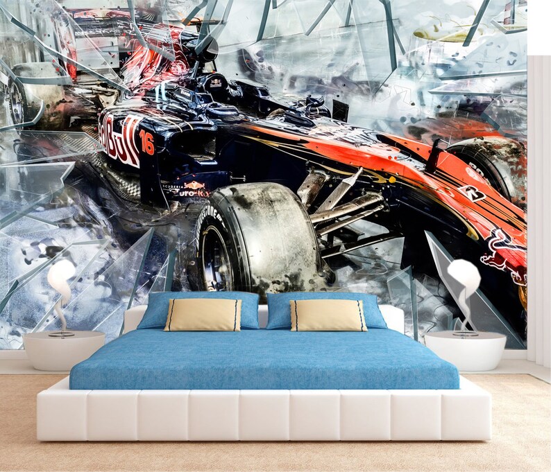 Op de afbeelding: Een grote muurschildering met een Formule 1-raceauto in zwart en rood, die lijkt door gebroken glas te breken. De auto heeft nummer 16. De muurschildering bevindt zich boven een bed met een blauw dekbed en witte nachtkastjes.