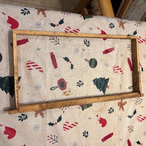 May include: A wooden frame with a light brown finish. The frame is rectangular and has a simple design.