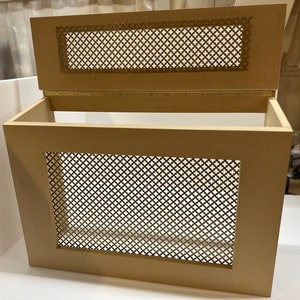 May include: A wooden box with a hinged lid and a decorative metal mesh panel on the front and lid. The box is light brown in color and has a simple design.