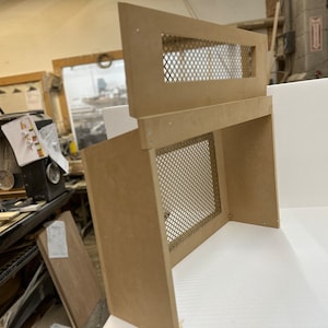 May include: A wooden box with a metal mesh screen on the front. The box is unfinished and has a light brown color.