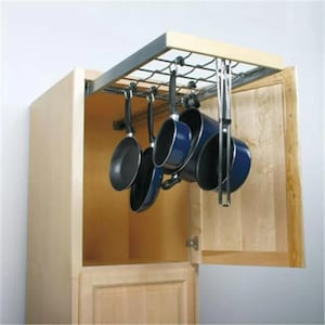 May include: A kitchen cabinet with an open door revealing a pull-down pot rack. The rack holds several blue pots and pans. The cabinet is light wood, and the rack is metal.