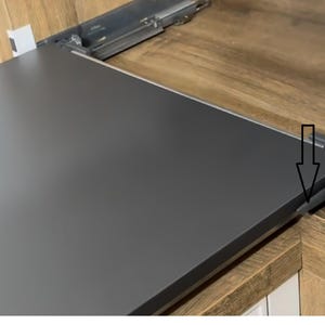 May include: Close-up of a dark gray pull-out shelf with a wooden frame. The shelf is partially extended, revealing the mechanism that allows it to slide out.