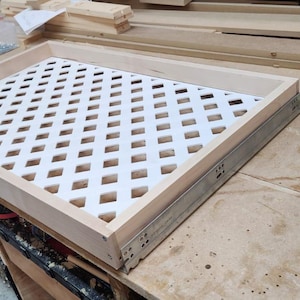 May include: A wooden tray with a white diamond-shaped lattice insert. The tray is mounted on metal drawer slides.