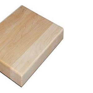May include: A rectangular wooden cutting board with a light brown color. The board has a smooth surface and is made of solid wood.
