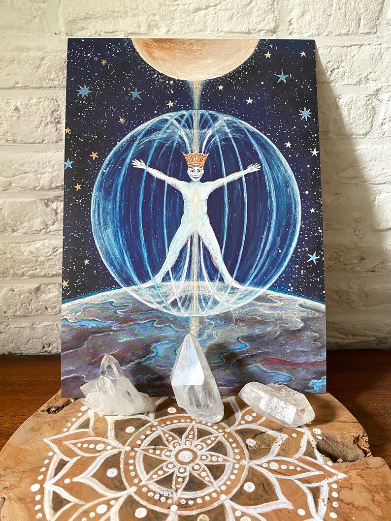 May include: A painting of a person with outstretched arms inside a sphere of light, surrounded by stars and a crescent moon. The person is wearing a crown and is surrounded by a blue and white aura. The painting is on a wooden surface with a mandala design and three clear quartz crystals.