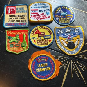May include: A collection of seven embroidered patches featuring American Bowling Congress league champion awards from various years, including Brunswick 600 series and ABC Triplicate Club designs with colorful thread, text, and bowling imagery.