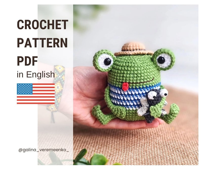 May include: Crochet pattern PDF in English for a green frog wearing a straw hat and holding a small black fly. The frog is wearing a blue and white striped shirt.