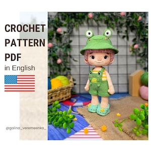 May include: A crochet doll wearing a green frog-themed bucket hat, a yellow and white striped shirt, and green overalls with small yellow star accents on the shoes. The text CROCHET PATTERN PDF in English is visible on the left side of the image.