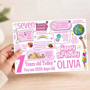 May include: A rectangular birthday card featuring the text Seven, Happy Birthday, and Olivia. The design includes colourful illustrations of a slot machine, rainbow, ladybird, globe, giraffe, and pyramids, with facts about the number seven.