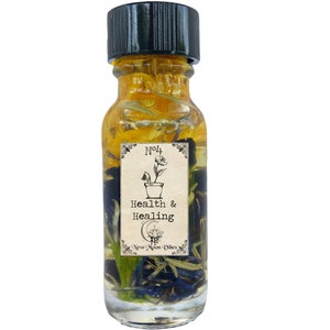 May include: A small glass bottle filled with yellow oil and dried flowers. The bottle has a black cap and a label that reads "No.4 Health & Healing New Moon Vibes".