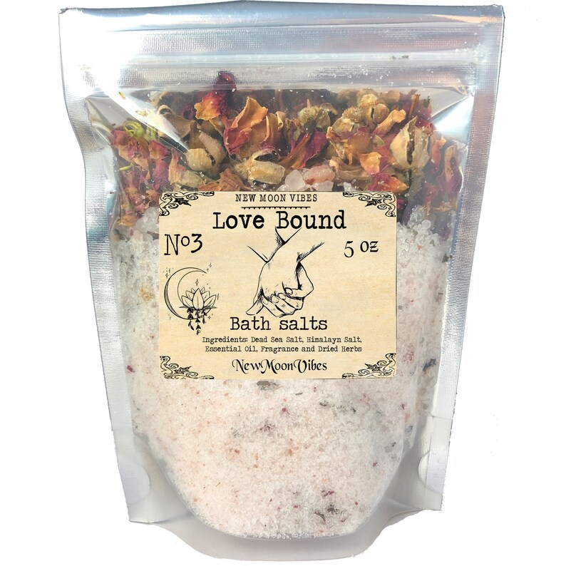 Peut inclure: Un sac en plastique transparent rempli de sels de bain blancs et de p&eacute;tales de rose s&eacute;ch&eacute;s. Le sac porte une &eacute;tiquette sur laquelle est inscrit "N&deg;3 Love Bound 5 oz Bath salts Ingredients: Dead Sea Salt, Himalayan Salt, Essential Oil, Fragrance and Dried Herbs New Moon Vibes"
