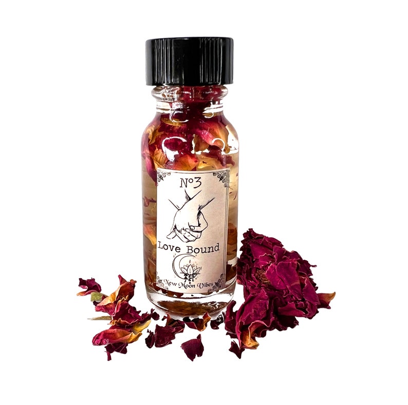 K&ouml;nnte beinhalten: Eine kleine Glasflasche gef&uuml;llt mit einer klaren Fl&uuml;ssigkeit und Rosenbl&uuml;ten. Die Flasche hat einen schwarzen Verschluss und ein Etikett mit der Aufschrift "No. 3 Love Bound New Moon Vibes".
