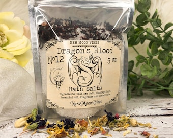 Peut inclure: Un petit sac en plastique transparent rempli de sels de bain. Le sac porte une étiquette sur laquelle est écrit "New Moon Vibes Dragon's Blood No. 12 5 oz Bath salts Ingredients: Dead Sea Salt, Himalayan Salt Essential Oil, Fragrance and Dried Herbs New Moon Vibes".