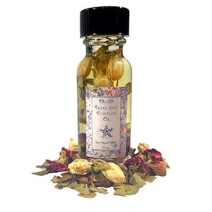 May include: A small glass bottle with a black cap filled with a yellow liquid and white flowers. The label reads "No.20 Fame and Fortune Oil" with a five-pointed star and the words "New Moon Vibes" and "15 ML".