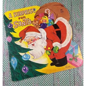 May include: A vintage children's pop-up book titled "A Surprise for Santa". The cover features a cartoon illustration of Santa Claus peeking at a Christmas tree with ornaments. He is carrying a bag full of gifts and a teddy bear.