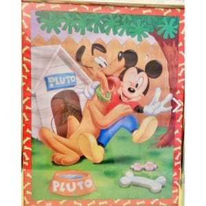 Puede incluir: Una ilustración enmarcada de Mickey Mouse y Pluto el perro. Mickey lleva una camisa roja y pantalones azules y está sosteniendo la pata de Pluto. Pluto lleva un collar verde y está mirando a Mickey. La ilustración está sobre un fondo verde con una caseta de perro que dice "Pluto" en ella.