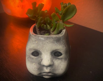 Small doll head planter.