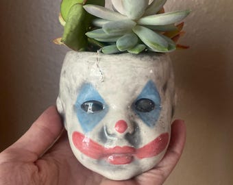Vaso di fiori a forma di testa di pagliaccio.