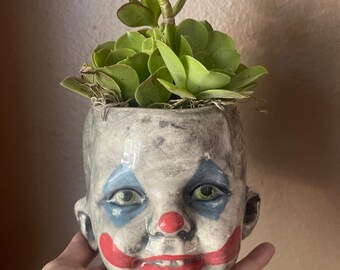 Vaso di fiori a forma di testa di pagliaccio.