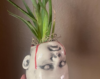 Creepy doll upside down planter
