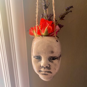 Hanging baby head vase